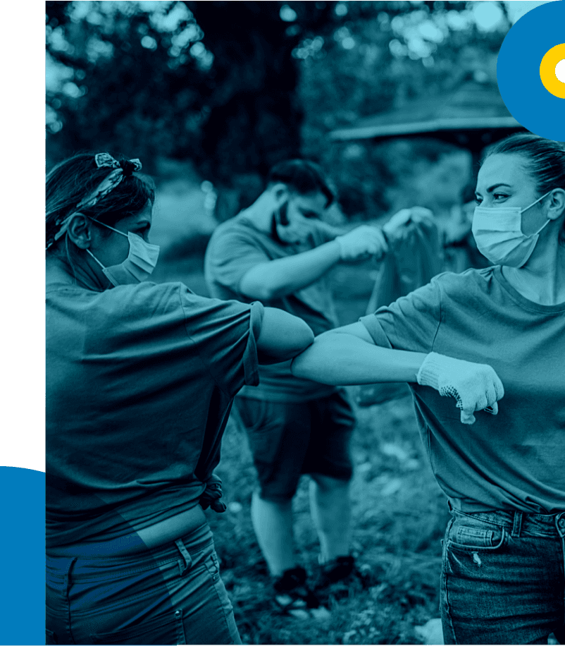 Young women bumping elbows while working outdoors